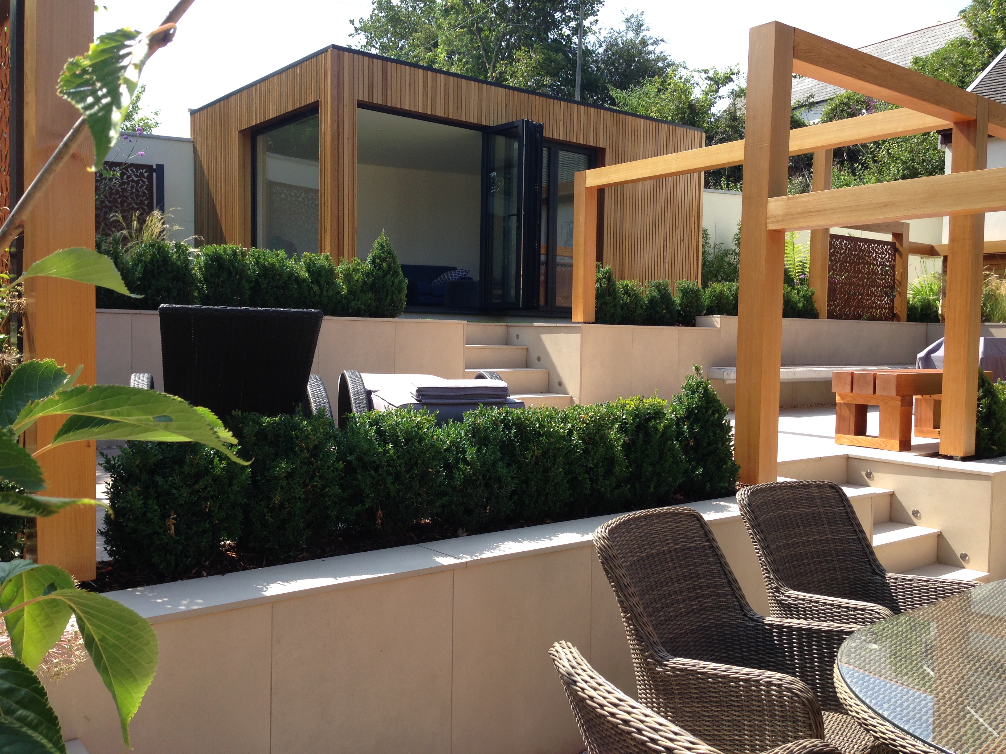 view into the contemporary garden with seating pergola features and summerhouse